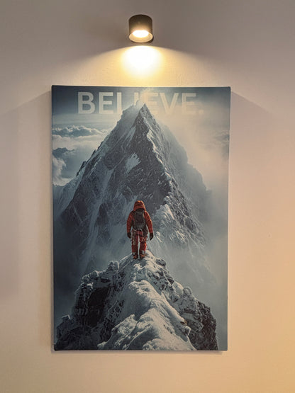 Leinwand mit einem Bergsteiger der vor einem großen Berg steht im Hintergrund ein Wort "Believe"
